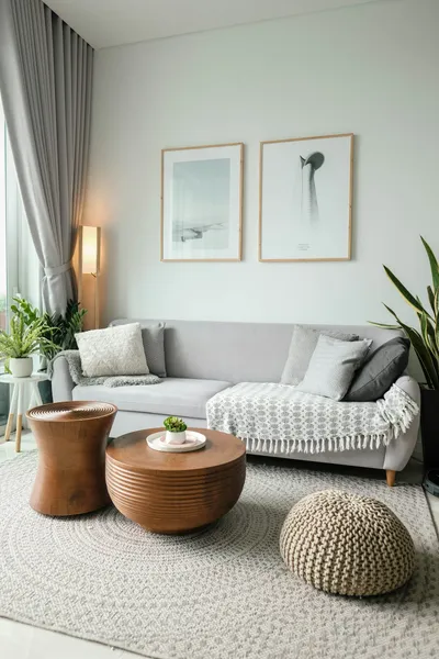 A tidy, staged living room with large windows and minimal furniture